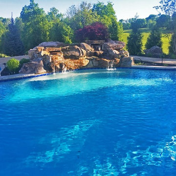 Pool with custom boulder waterfall and flagstone pool deck.
