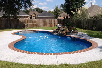 Inspiration for a large timeless backyard brick and kidney-shaped natural pool fountain remodel in Miami