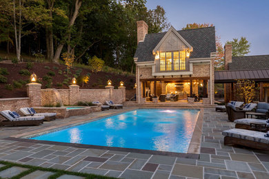 Modelo de piscina rectangular en patio trasero con adoquines de piedra natural