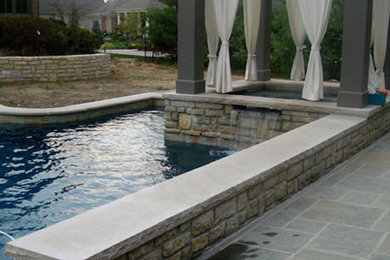 На фото: большой спортивный, прямоугольный бассейн на заднем дворе с джакузи и покрытием из каменной брусчатки с