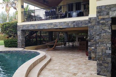 Diseño de piscina con fuente natural exótica grande tipo riñón en patio trasero con suelo de baldosas