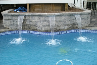 Example of a backyard stone and custom-shaped natural pool fountain design in DC Metro