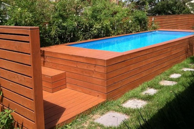 Huge elegant backyard rectangular and stone aboveground hot tub photo in Other