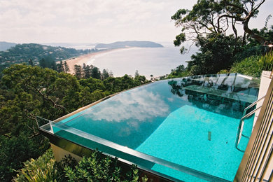 Imagen de casa de la piscina y piscina infinita contemporánea grande interior y rectangular con adoquines de piedra natural