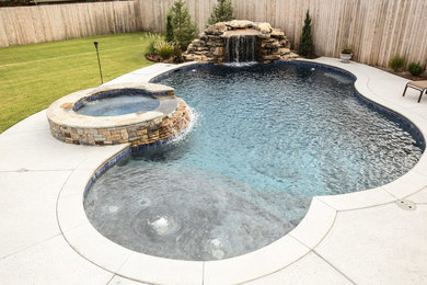 Foto de piscina con fuente rústica de tamaño medio a medida en patio trasero con losas de hormigón