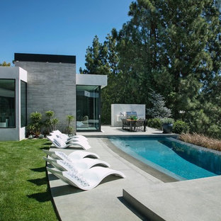 Idee per una piscina a sfioro infinito moderna personalizzata dietro casa con lastre di cemento