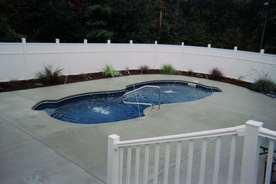 Foto de piscina con fuente natural tipo riñón en patio trasero con losas de hormigón