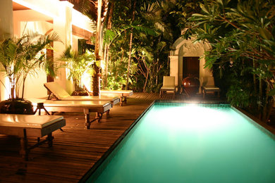 Example of a large trendy backyard rectangular pool fountain design in Miami with decking
