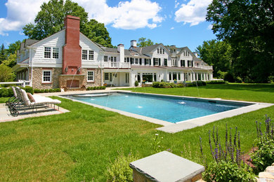 Exempel på en rektangulär pool på baksidan av huset, med spabad