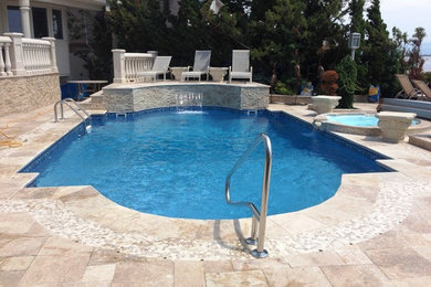 Modelo de piscina con fuente natural de tamaño medio a medida en patio trasero con adoquines de piedra natural