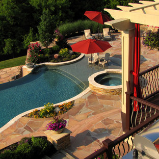 Photo of an expansive traditional backyard custom-shaped lap pool in New York with a hot tub and natural stone pavers.