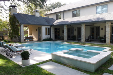 Immagine di una piscina design personalizzata di medie dimensioni e dietro casa con una vasca idromassaggio e lastre di cemento