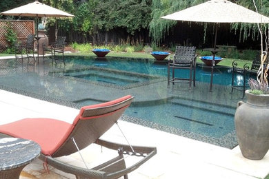 Diseño de piscinas y jacuzzis naturales clásicos renovados de tamaño medio a medida en patio trasero con losas de hormigón