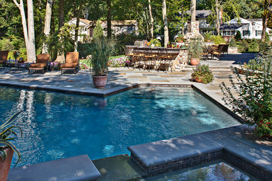 Пример оригинального дизайна: большой бассейн произвольной формы на заднем дворе в классическом стиле с джакузи и покрытием из каменной брусчатки