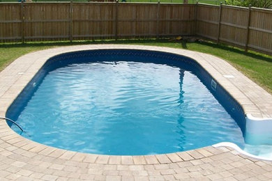 На фото: круглый бассейн среднего размера на заднем дворе с покрытием из декоративного бетона
