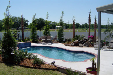 Modelo de piscinas y jacuzzis tradicionales renovados grandes a medida en patio trasero con losas de hormigón