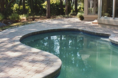 Mid-sized elegant backyard brick and custom-shaped pool photo in Charlotte