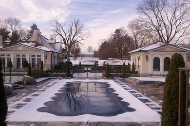 На фото: большой наземный, прямоугольный бассейн на заднем дворе в классическом стиле с домиком у бассейна и покрытием из каменной брусчатки
