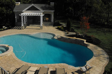 Modelo de piscinas y jacuzzis mediterráneos extra grandes a medida en patio trasero con adoquines de hormigón