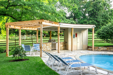 Trendy backyard stone and round lap pool house photo in Baltimore