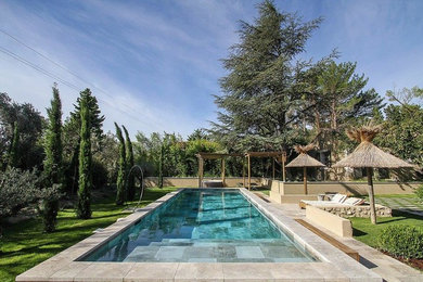 Großer Mediterraner Schwimmteich hinter dem Haus in individueller Form mit Wasserspiel und Natursteinplatten in Dallas