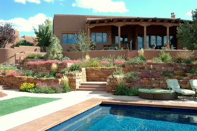 Foto de piscina de estilo americano de tamaño medio rectangular en patio trasero con losas de hormigón