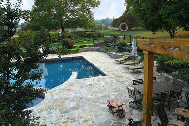 Foto de piscinas y jacuzzis naturales actuales grandes a medida en patio trasero con adoquines de piedra natural