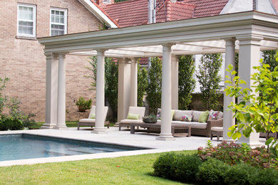 Imagen de piscina alargada clásica grande rectangular en patio trasero con adoquines de hormigón