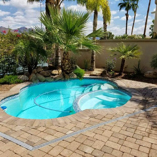 Photo of a small traditional backyard custom-shaped pool in San Diego with a hot tub.