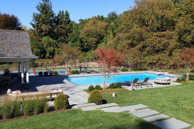 Diseño de casa de la piscina y piscina natural tradicional grande rectangular en patio trasero con adoquines de hormigón