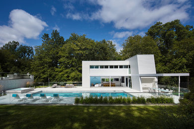 Imagen de casa de la piscina y piscina moderna de tamaño medio rectangular en patio trasero con losas de hormigón