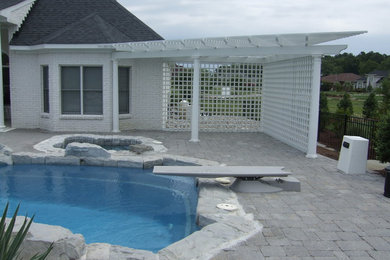Hot tub - large contemporary backyard stone and rectangular hot tub idea in Other