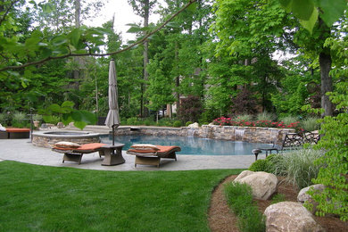 Imagen de piscinas y jacuzzis elevados clásicos en patio trasero con adoquines de piedra natural