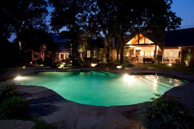 Imagen de piscina tradicional renovada grande a medida en patio trasero con adoquines de piedra natural