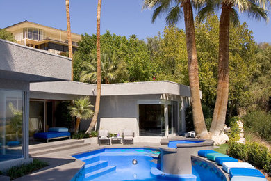 Imagen de piscina exótica a medida en patio trasero con losas de hormigón