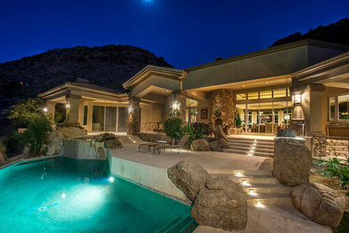 Example of a large classic backyard concrete paver and custom-shaped pool design in Phoenix