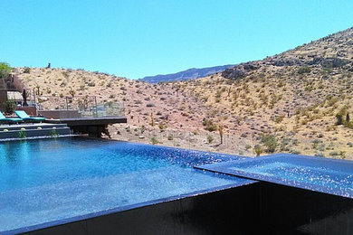 Inspiration for a huge contemporary backyard concrete and rectangular infinity hot tub remodel in Las Vegas