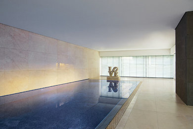 На фото: большой прямоугольный бассейн в доме в современном стиле с покрытием из плитки