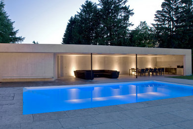 Großer Moderner Pool hinter dem Haus in rechteckiger Form mit Betonplatten in Stuttgart