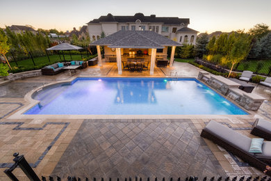 Pool house - large traditional backyard stamped concrete and custom-shaped lap pool house idea in Toronto