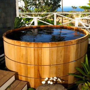 Foto di una piscina tropicale di medie dimensioni e dietro casa con una vasca idromassaggio e pedane