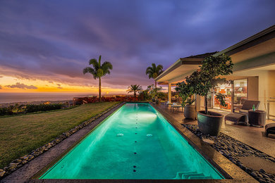 Large contemporary back rectangular lengths swimming pool in Hawaii with stamped concrete.