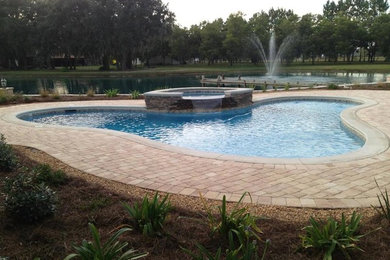 Backyard custom-shaped and concrete paver hot tub photo in Atlanta
