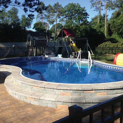 Example of a mid-sized classic backyard stone and custom-shaped aboveground pool design in Detroit
