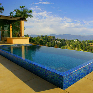 Mittelgroßer Moderner Infinity-Pool hinter dem Haus in rechteckiger Form mit Wasserspiel und Betonplatten in Los Angeles