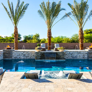 Ispirazione per una grande piscina moderna personalizzata dietro casa con fontane e pedane