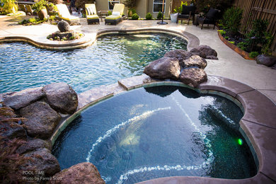 Mid-sized trendy backyard stamped concrete and custom-shaped pool fountain photo in Sacramento