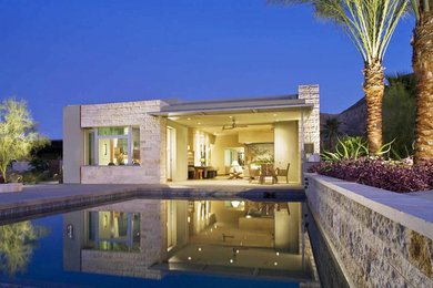 Example of a mid-sized minimalist backyard concrete paver and rectangular natural pool house design in Orange County