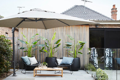 Idée de décoration pour une piscine arrière design de taille moyenne et sur mesure avec une terrasse en bois.