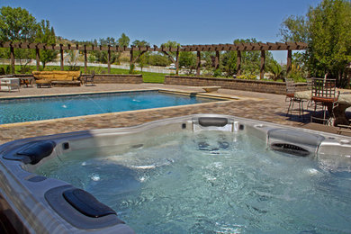 Inspiration for a large timeless backyard concrete paver and rectangular hot tub remodel in Other